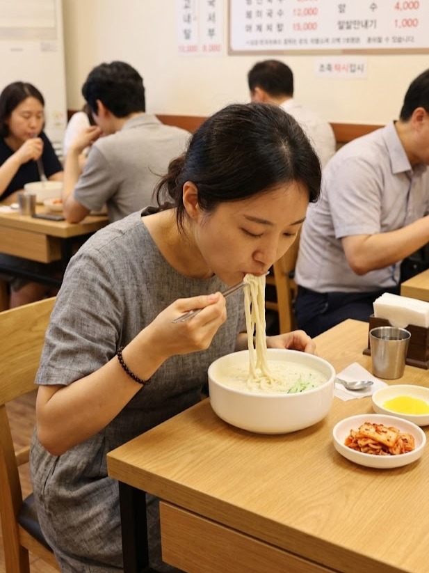 여름 식당에서 콩국수를 먹는 사람들 — 한국 여름의 일상 풍경